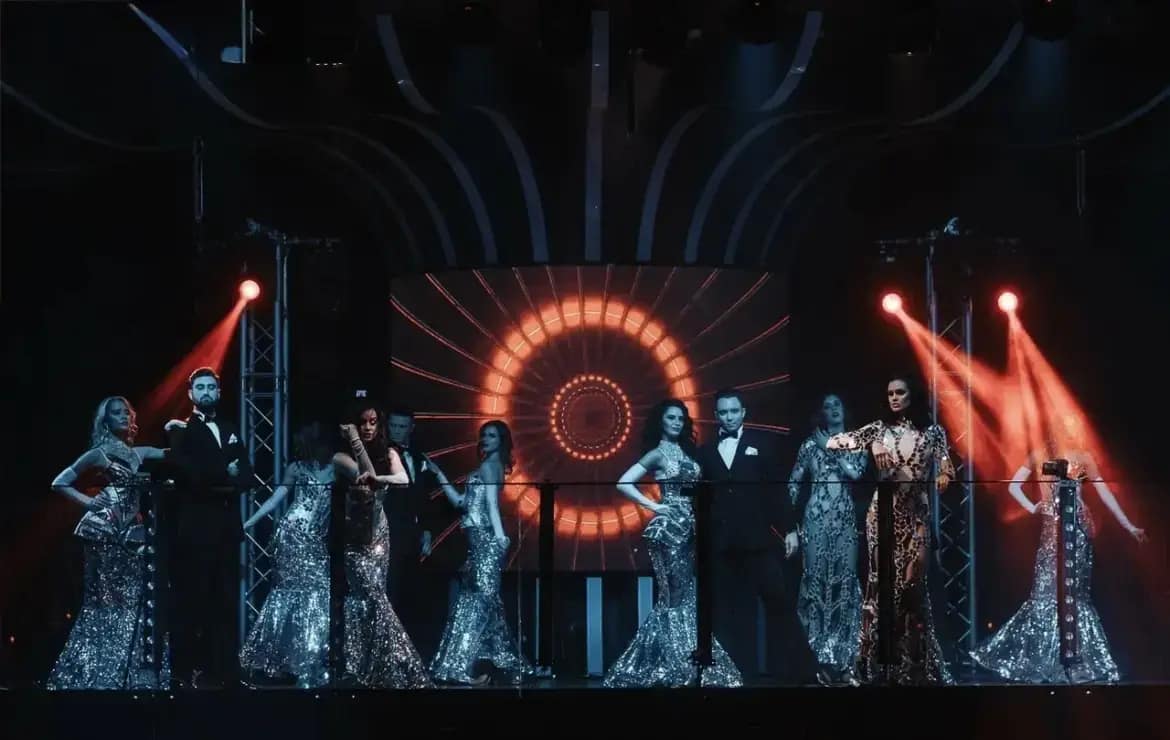 Cast in silver costumes on a themed stage