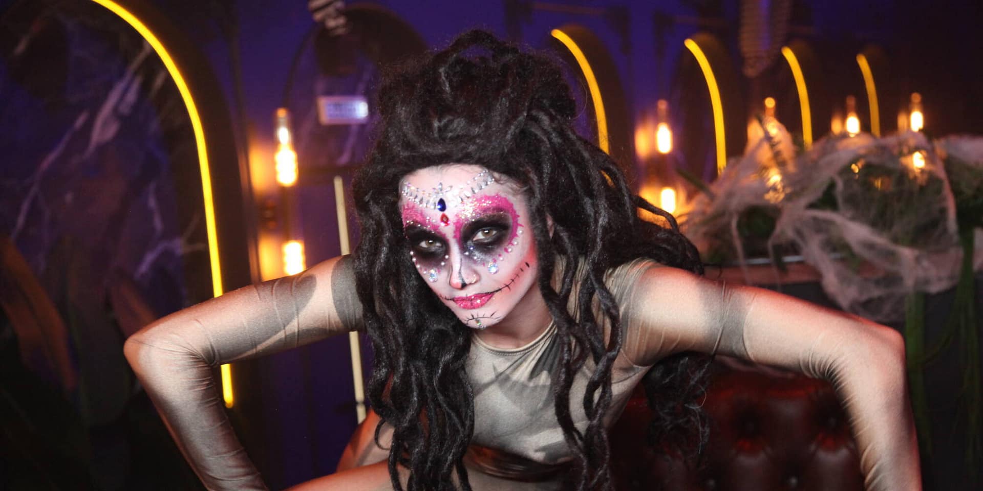 Themed event performer in sugar-skull make-up and dreadlocks