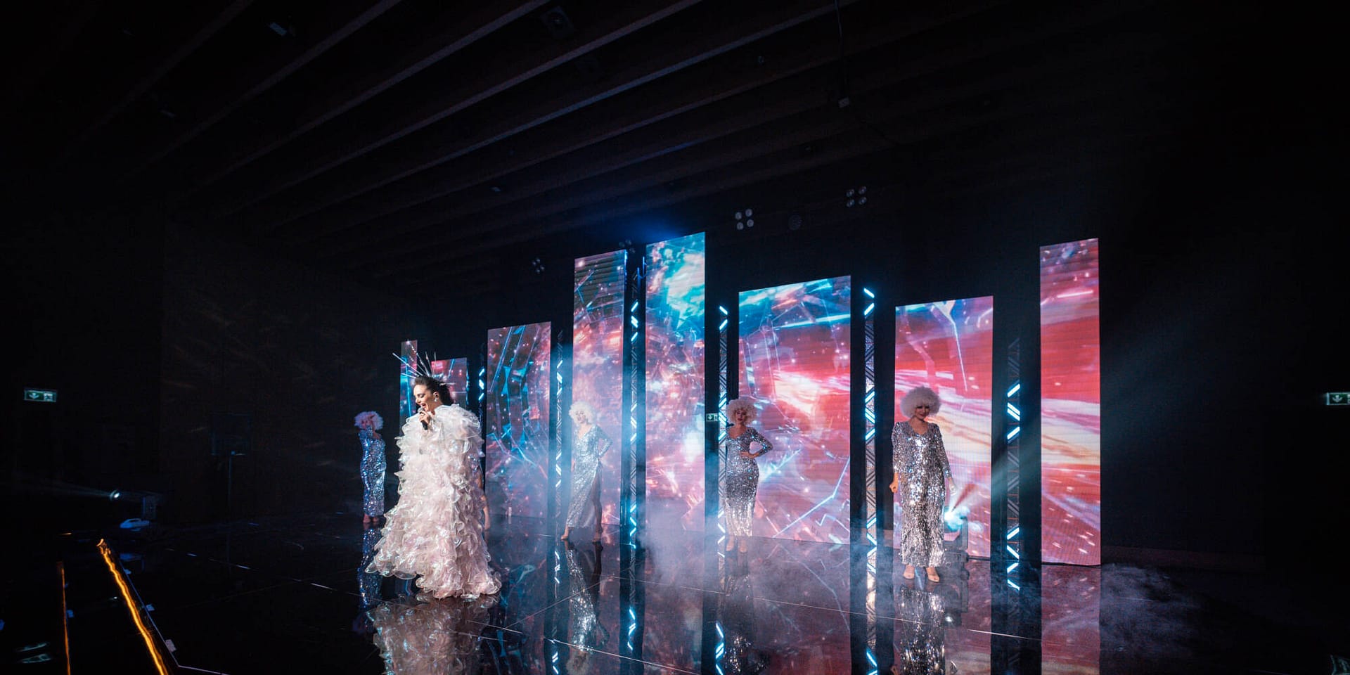 Costumed performers on an LED-screen catwalk at a corporate event